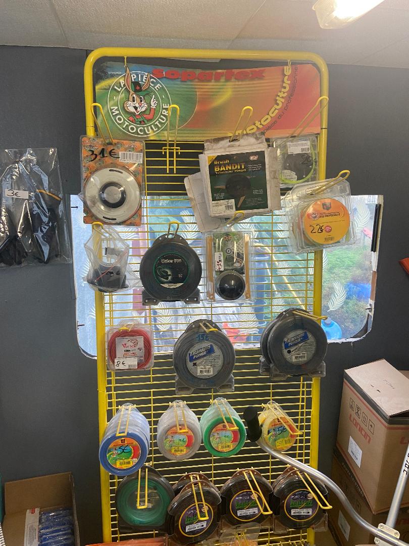 Bobines de fil pour débroussailleuse chez Pezet Motoculture à Laboutarié sur présentoir jaune en magasin spécialisé,